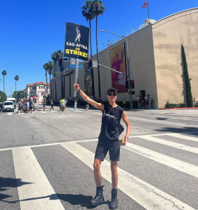 Vico Ortiz on SAG-AFTRA picket line in Hollywood, holding up SAG-AFTRA On Strike Sign