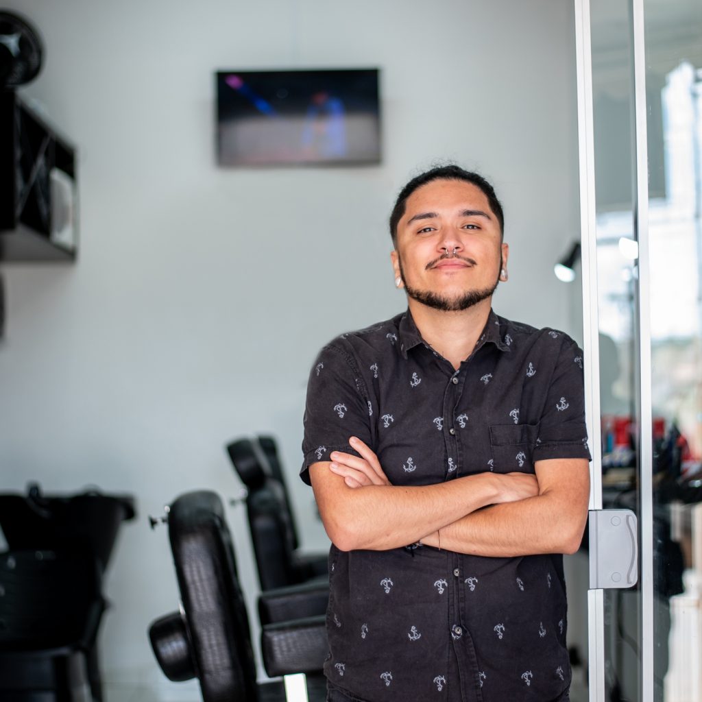 Shop trans: portrait of trans man at his barbershop. Credit: Drs Producoes